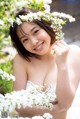 A woman in a white dress holding a bunch of white flowers.