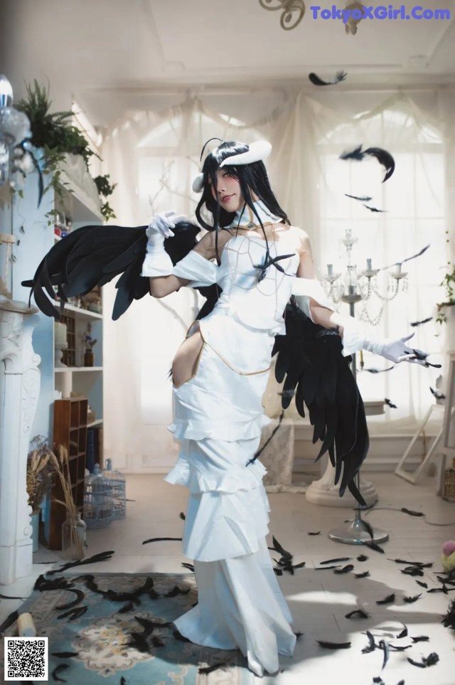 A woman in a white dress with black wings.