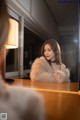 A woman sitting at a table in front of a mirror.