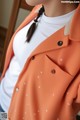 a woman wearing an orange jacket with white polka dots on it