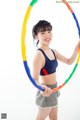 A young woman holding a hula hoop in her hands.