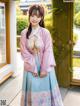 A woman in a pink and blue hanbok posing for the camera.