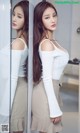 A woman standing in front of a mirror in a bathroom.